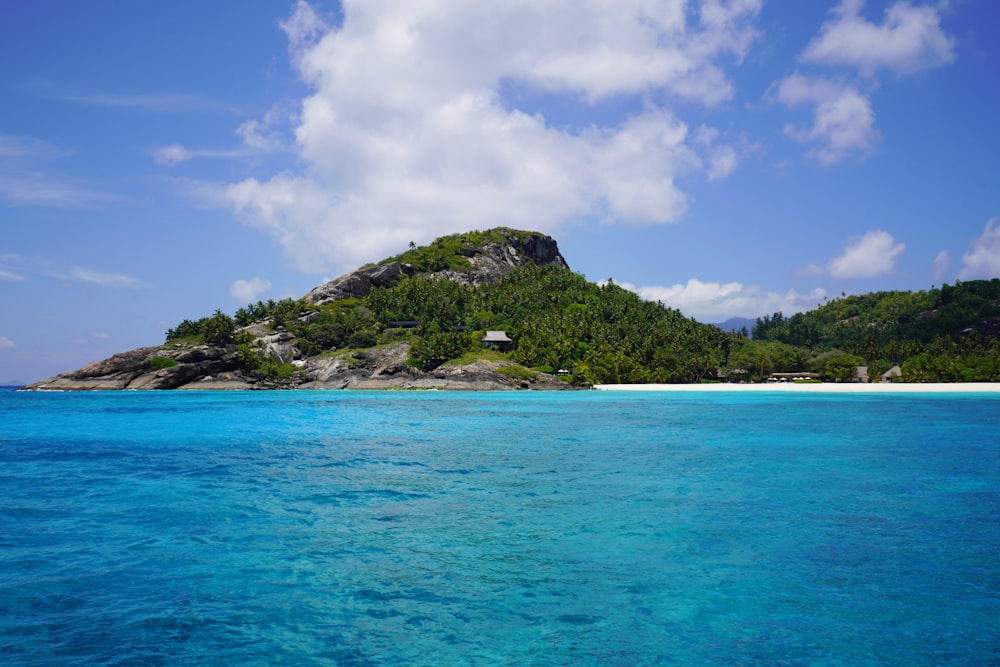 green island under blue sky and white clouds during daytime