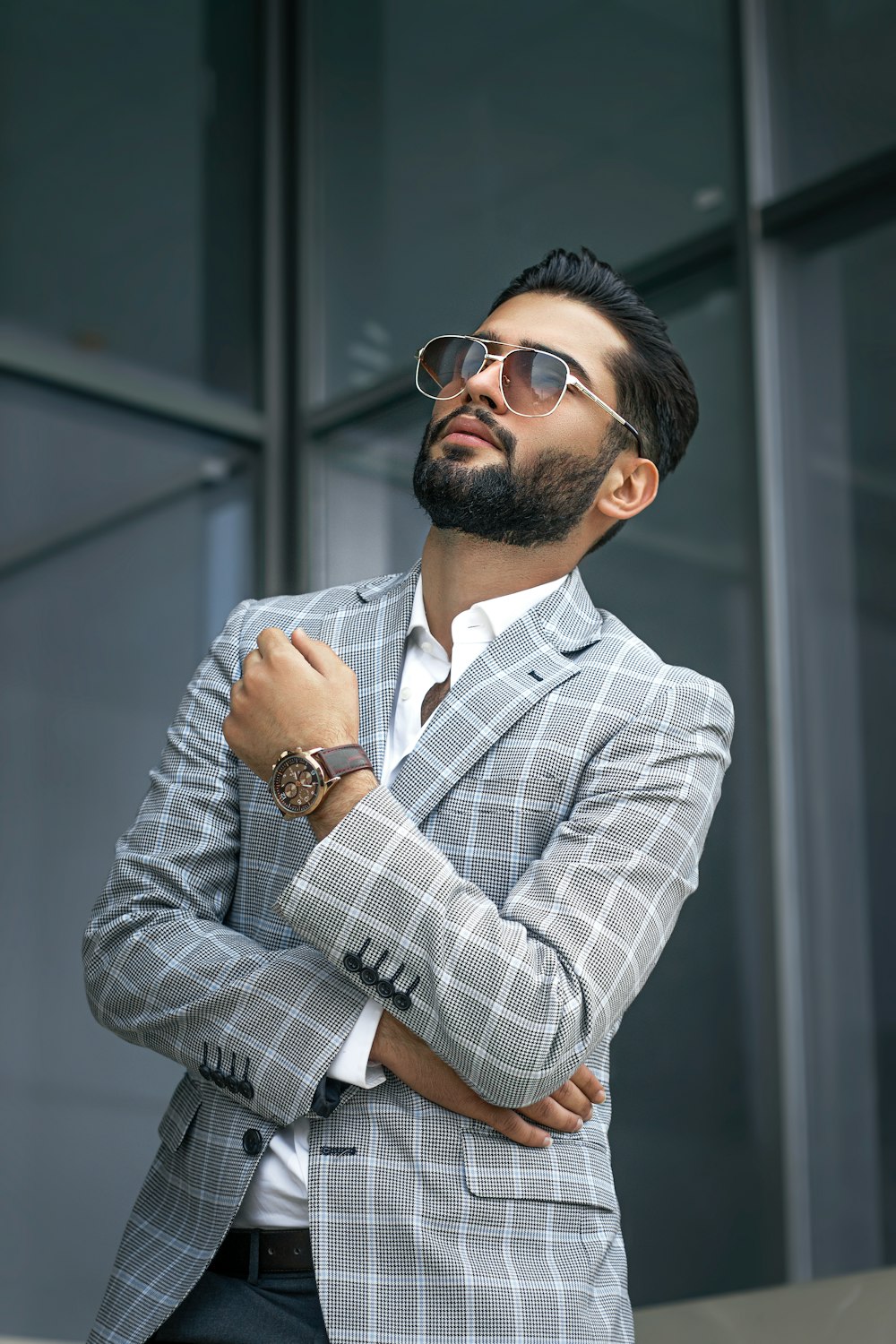 Hombre con gafas de sol negras y camisa de vestir a cuadros gris y blanco