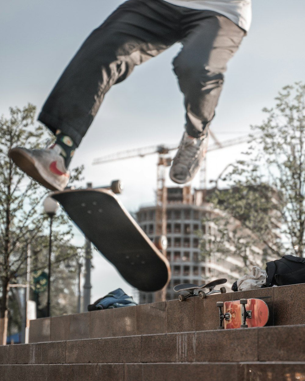 man in black pants and black shoes jumping on brown wooden fence during daytime