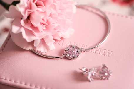 silver diamond ring on pink textile