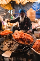 A chef preparing fresh jalebis in a bustling kitchen.