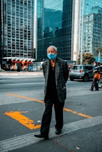 man in black and white checkered dress shirt standing on pedestrian lane during daytime
