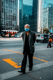 man in black and white checkered dress shirt standing on pedestrian lane during daytime