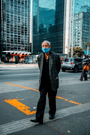 man in black and white checkered dress shirt standing on pedestrian lane during daytime