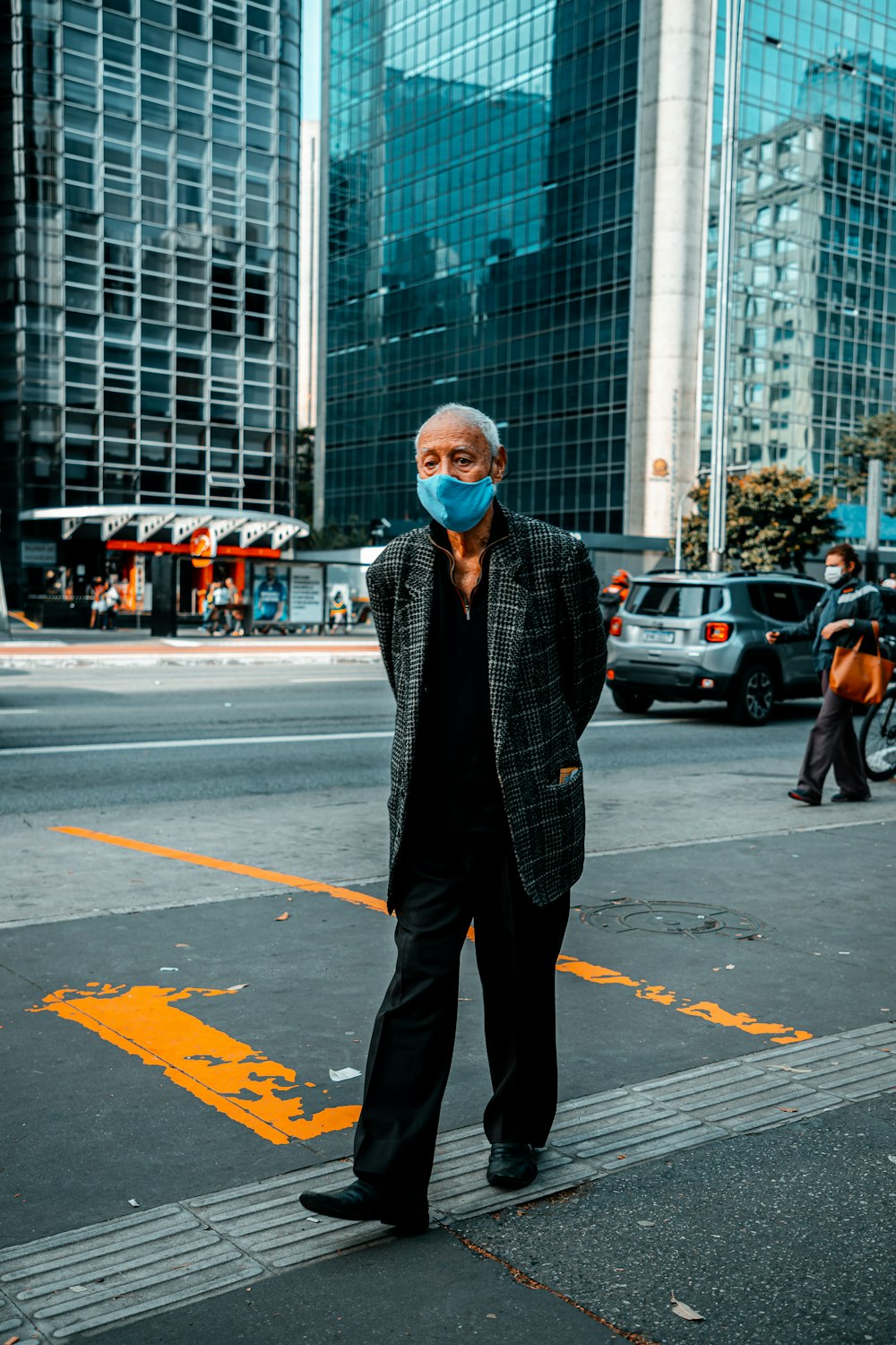 man in black and white checkered dress shirt standing on pedestrian lane during daytime