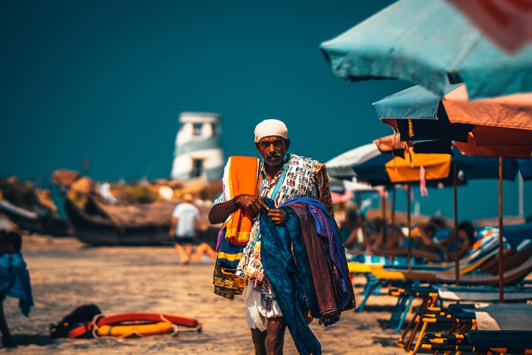 man in white and blue thobe standing on beach during daytime