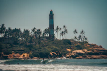 white and black lighthouse near body of water during night time