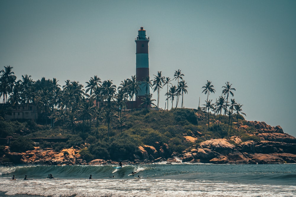 white and black lighthouse near body of water during night time