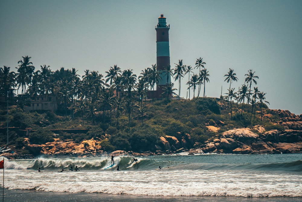 white and black lighthouse near body of water during night time