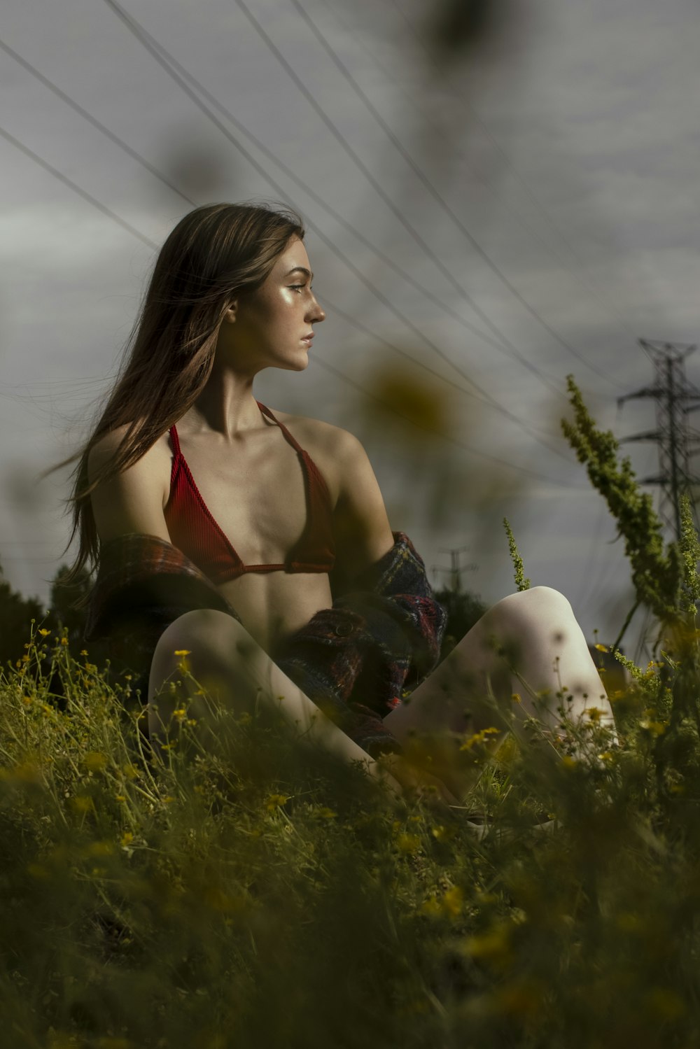 woman in black bikini sitting on green grass field during daytime