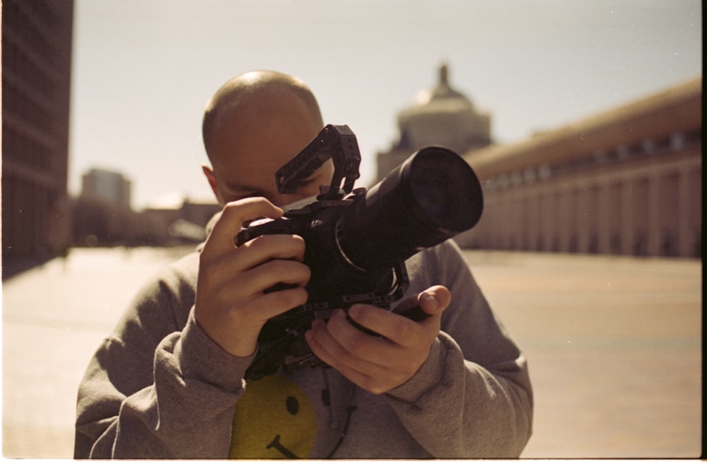 boy in beige coat holding black dslr camera