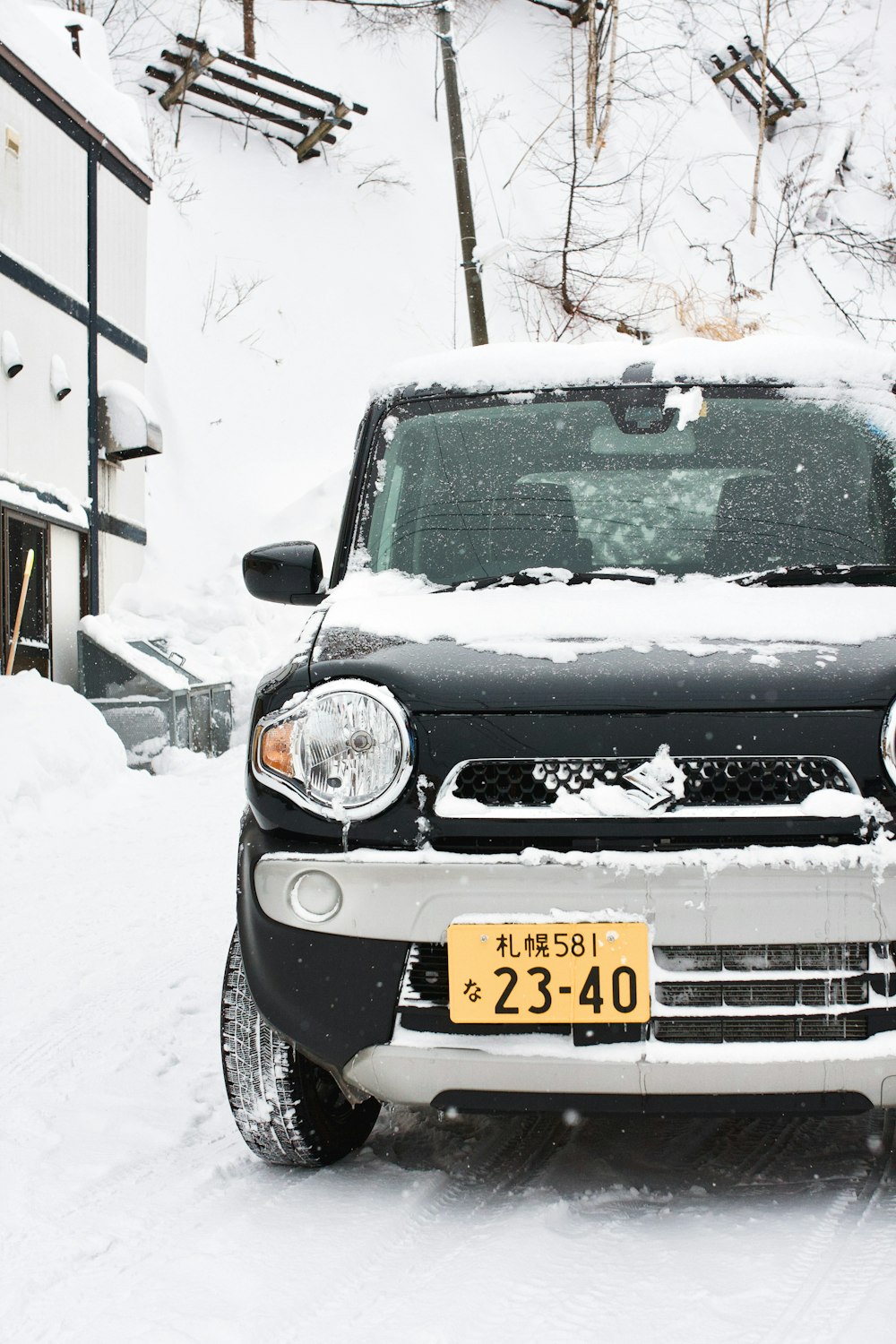 black nissan car on snow covered road during daytime