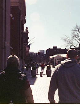 man in yellow jacket walking on sidewalk during daytime