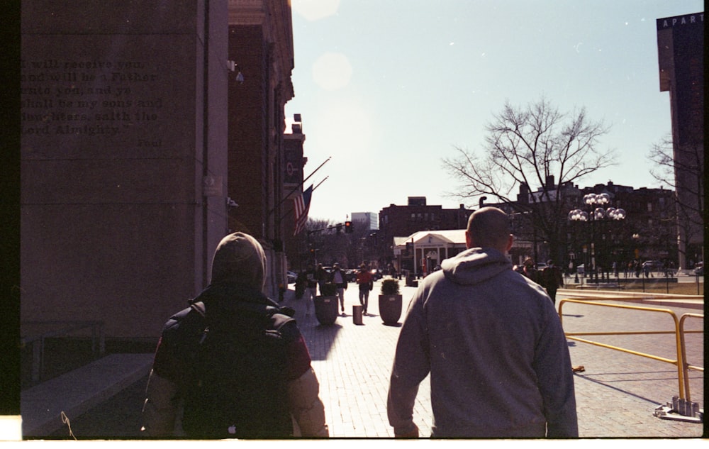 man in yellow jacket walking on sidewalk during daytime