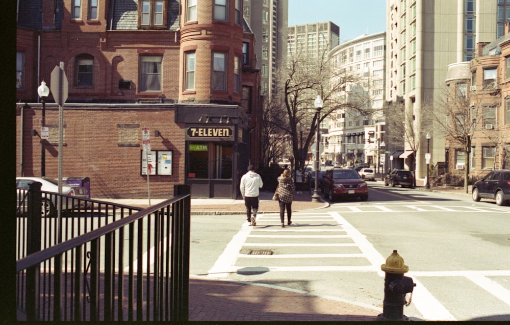 people walking on sidewalk near brown concrete building during daytime