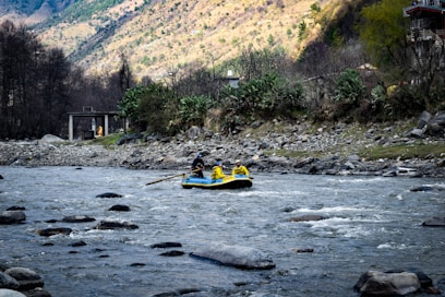 people riding on yellow kayak on river during daytime