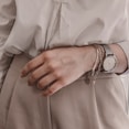 person in white dress shirt wearing silver link bracelet round analog watch