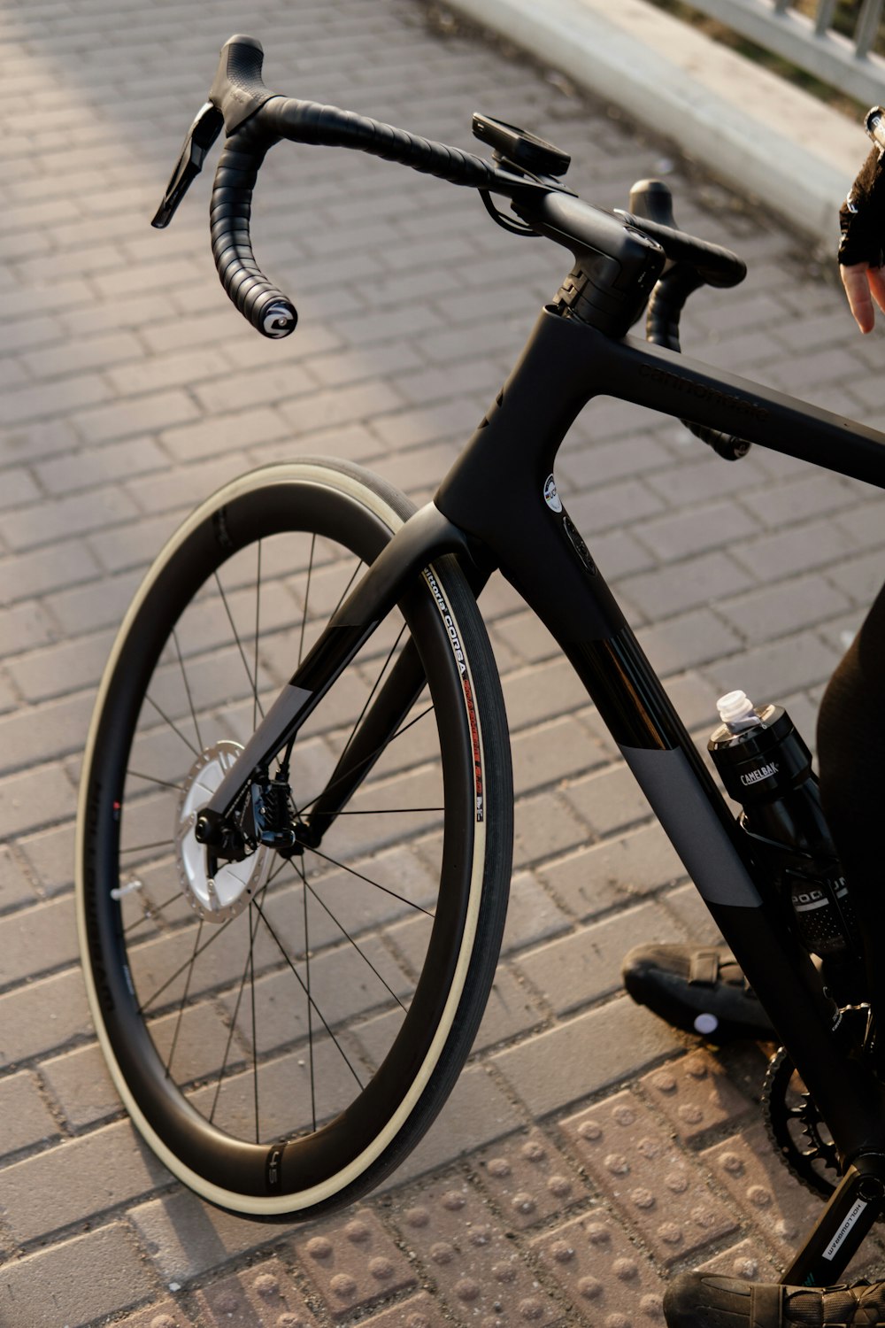 Bicicleta negra y gris sobre suelo de ladrillo marrón