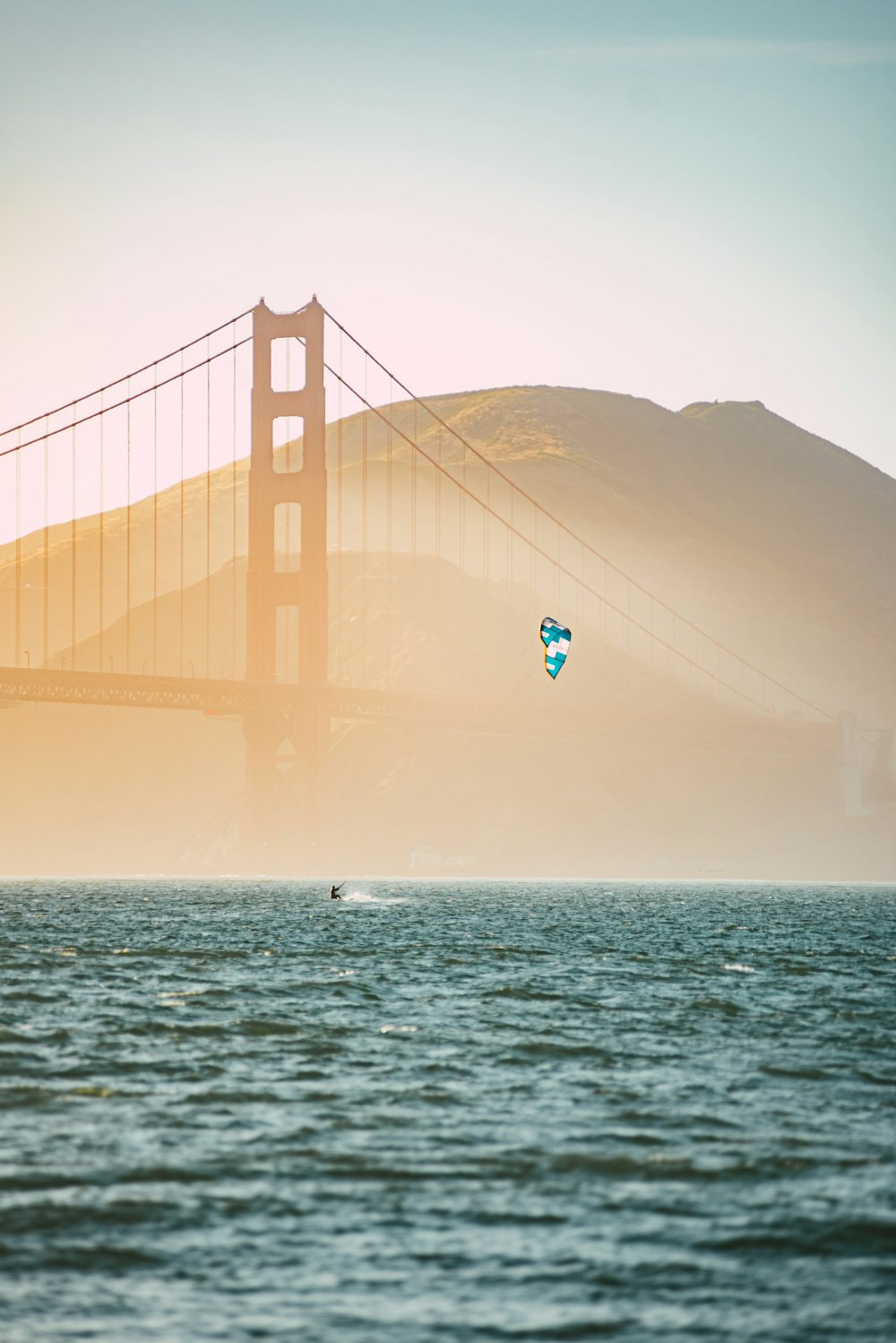 person in white shirt and black shorts jumping on golden gate bridge during daytime