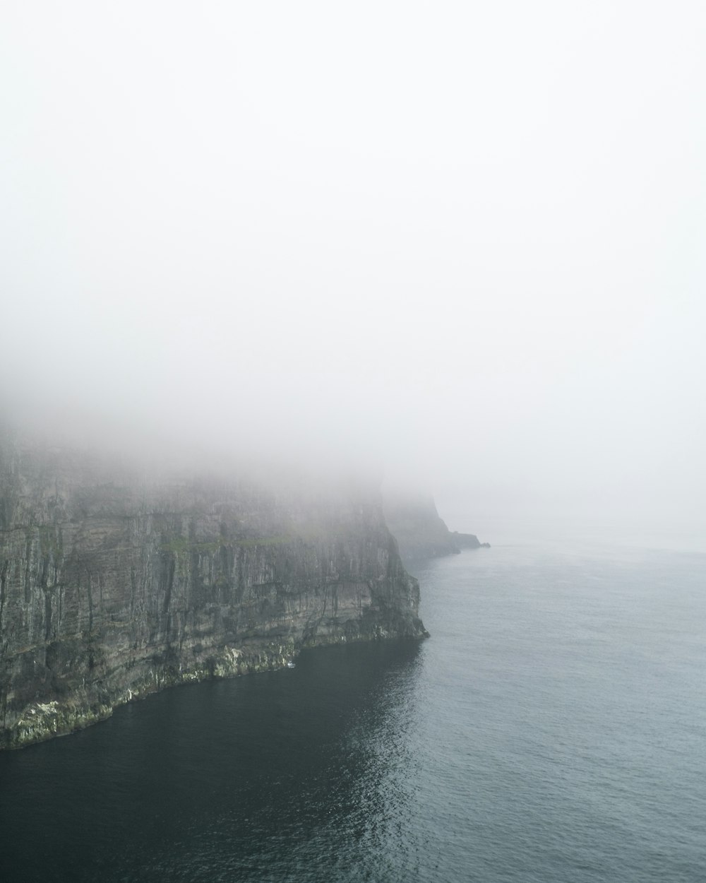 green and brown mountain beside body of water