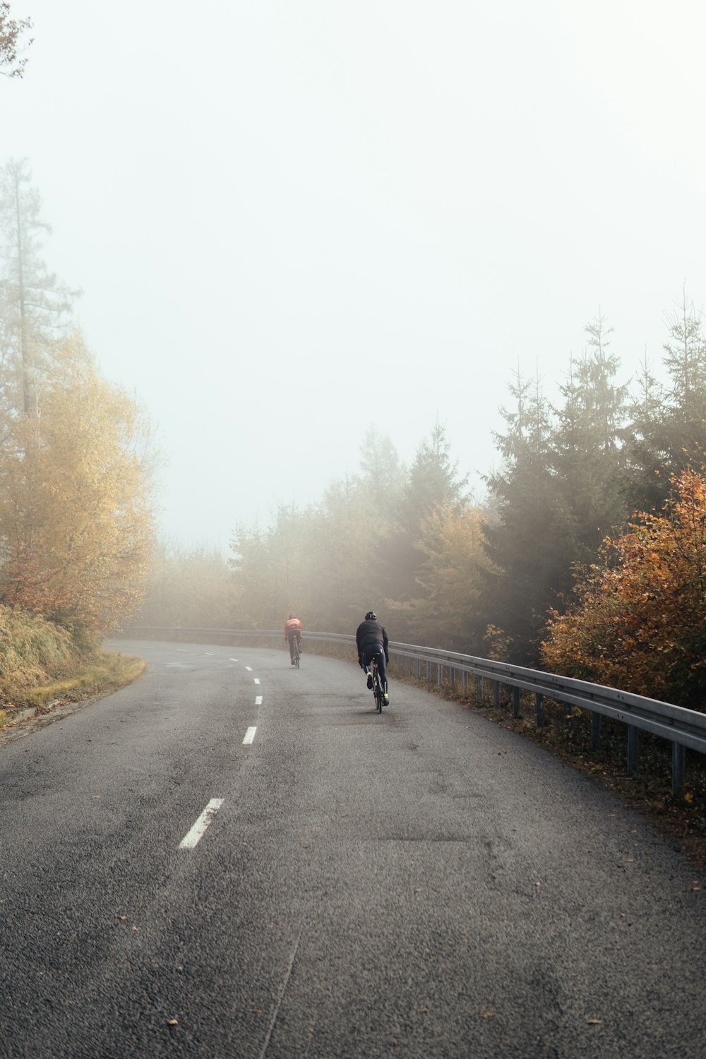 uomo in giacca nera che cammina sulla strada di cemento grigia durante il giorno