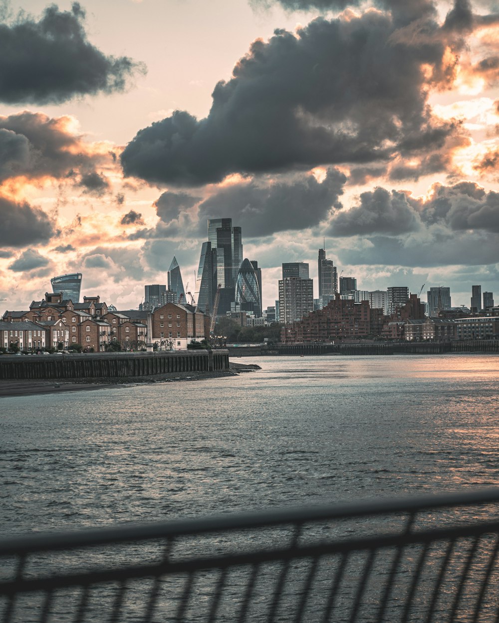 city skyline across body of water under cloudy sky during daytime