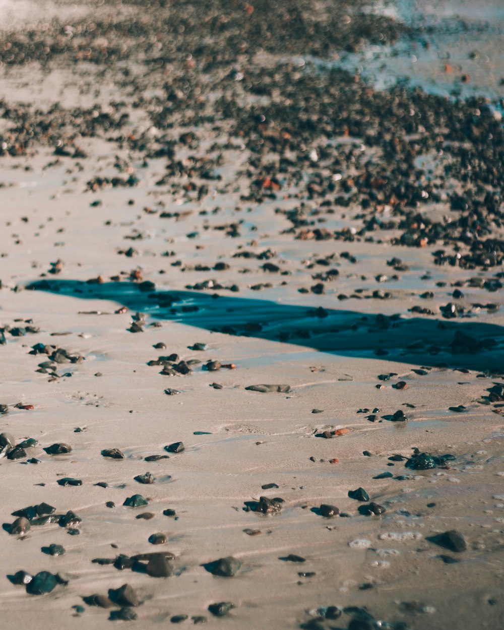 white and black stones on blue body of water during daytime