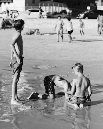 Children playing on a sandy beach with turquoise waves in the background