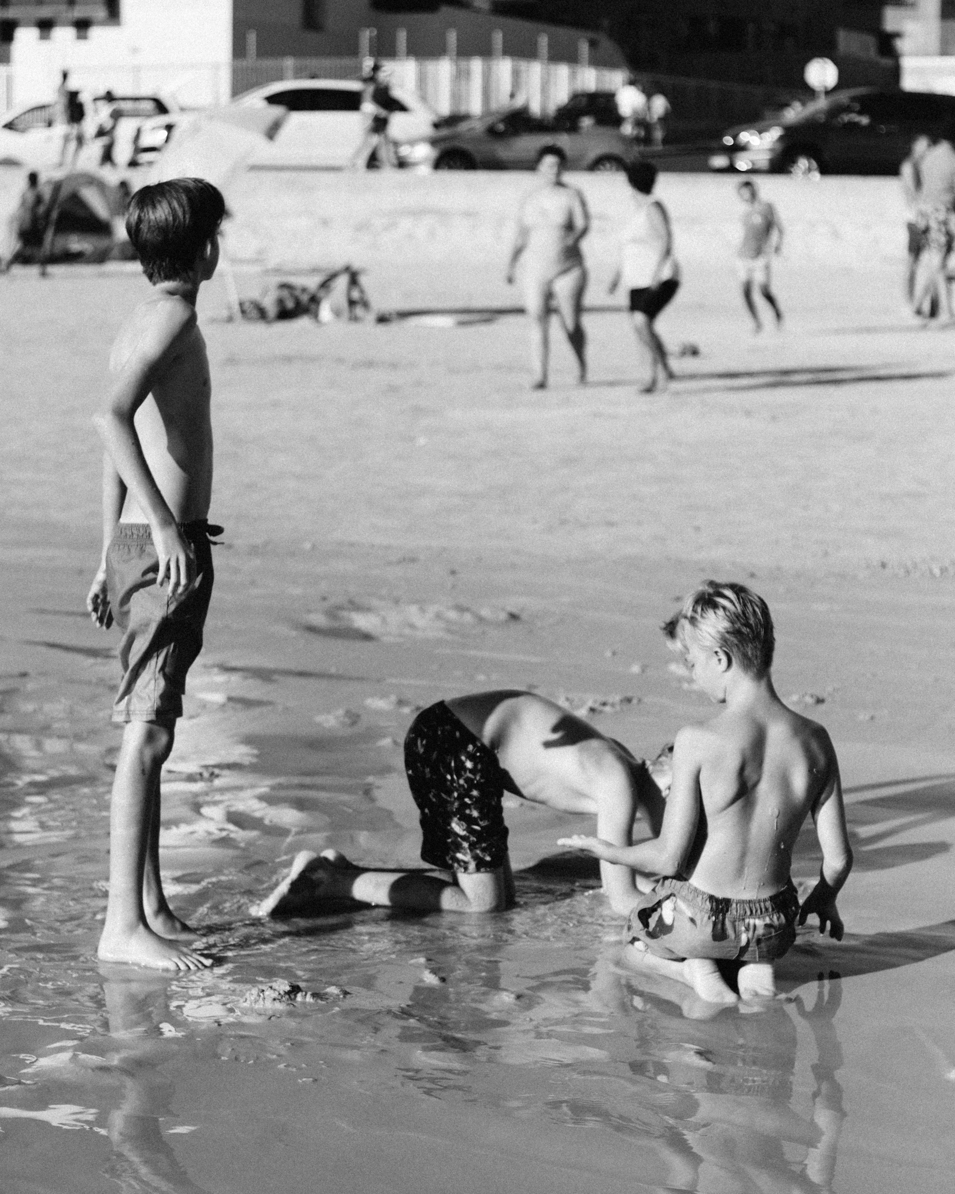 Kids gathered on a sandy beach, playing and exploring during a small group adventure day.