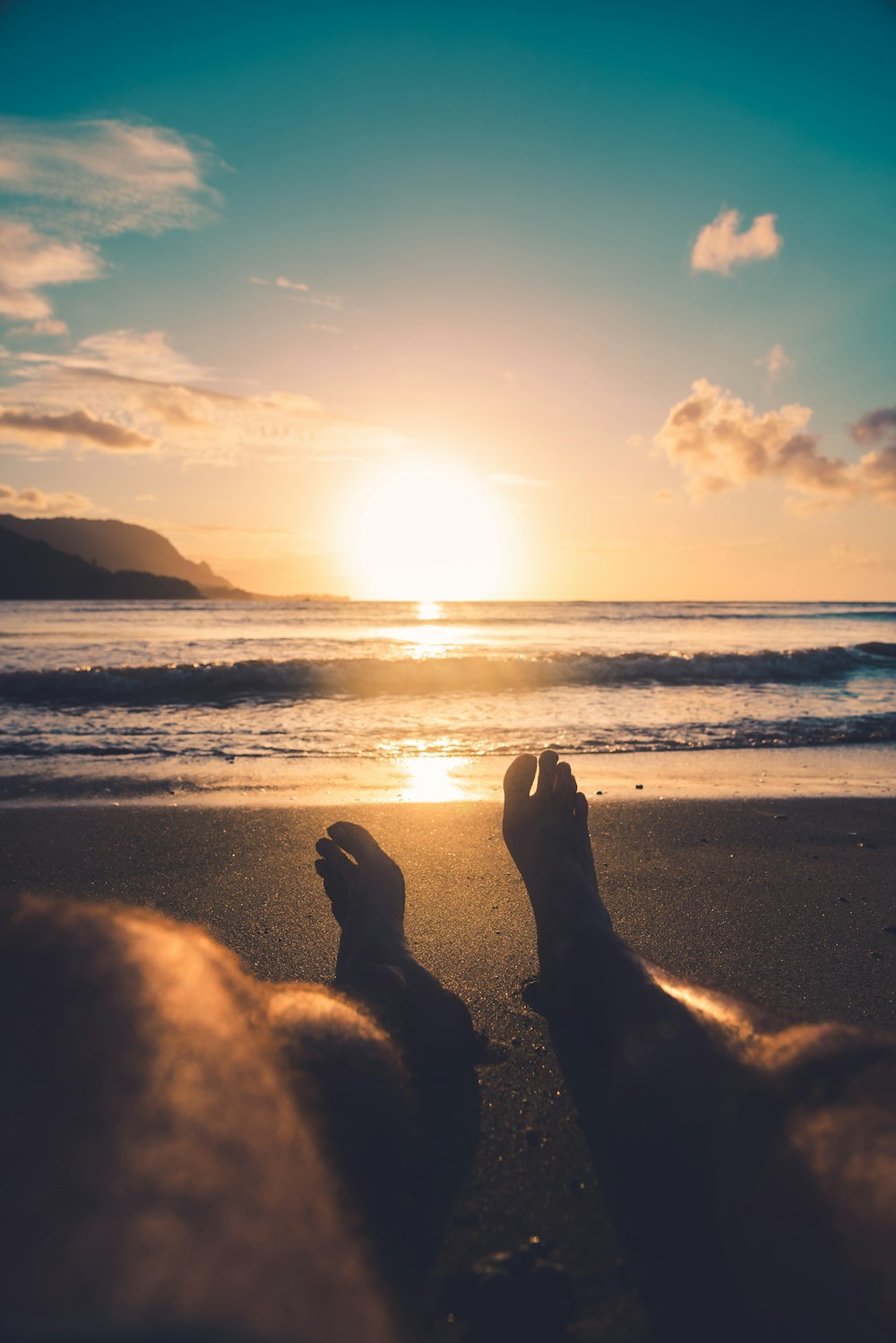 silhouette of person sitting on beach during sunset