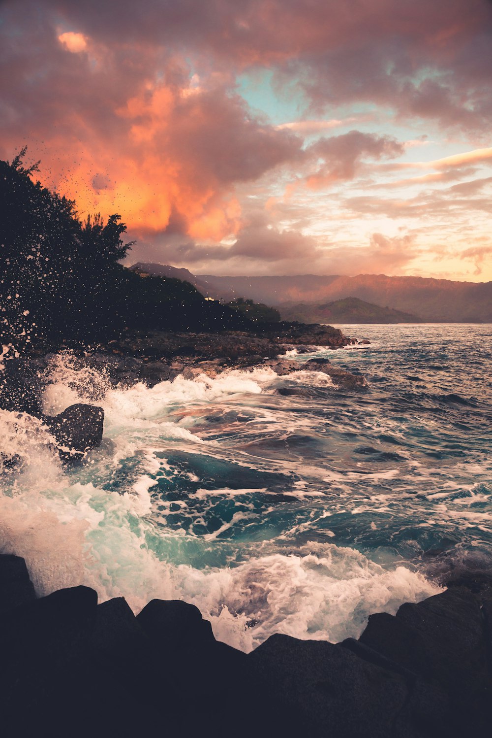 ocean waves crashing on rocks during sunset