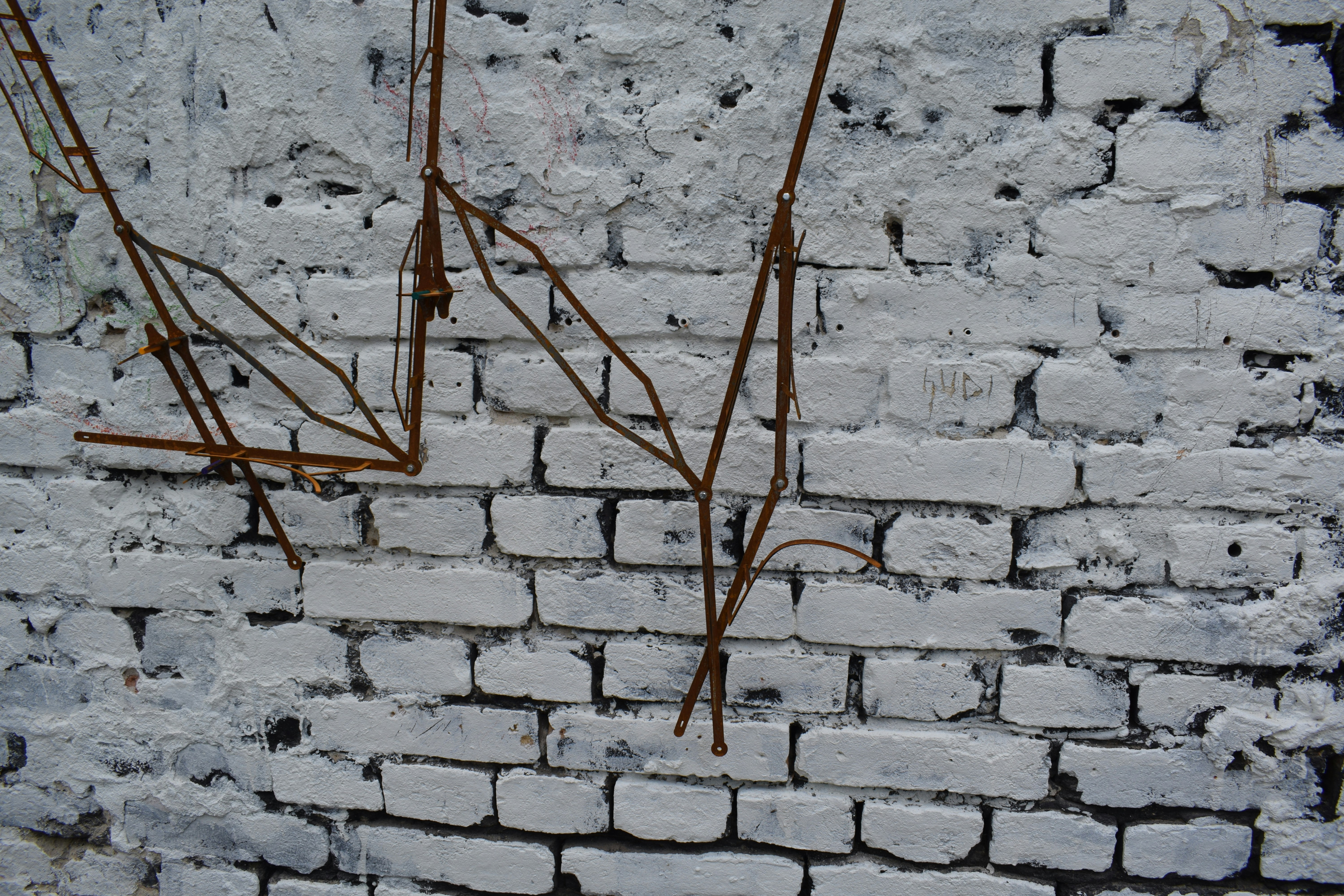 brown wooden stick on white brick wall