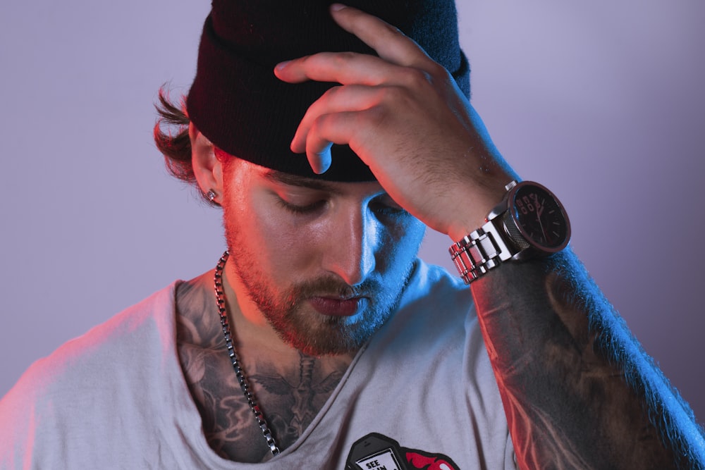 man in white shirt wearing black cap and silver watch