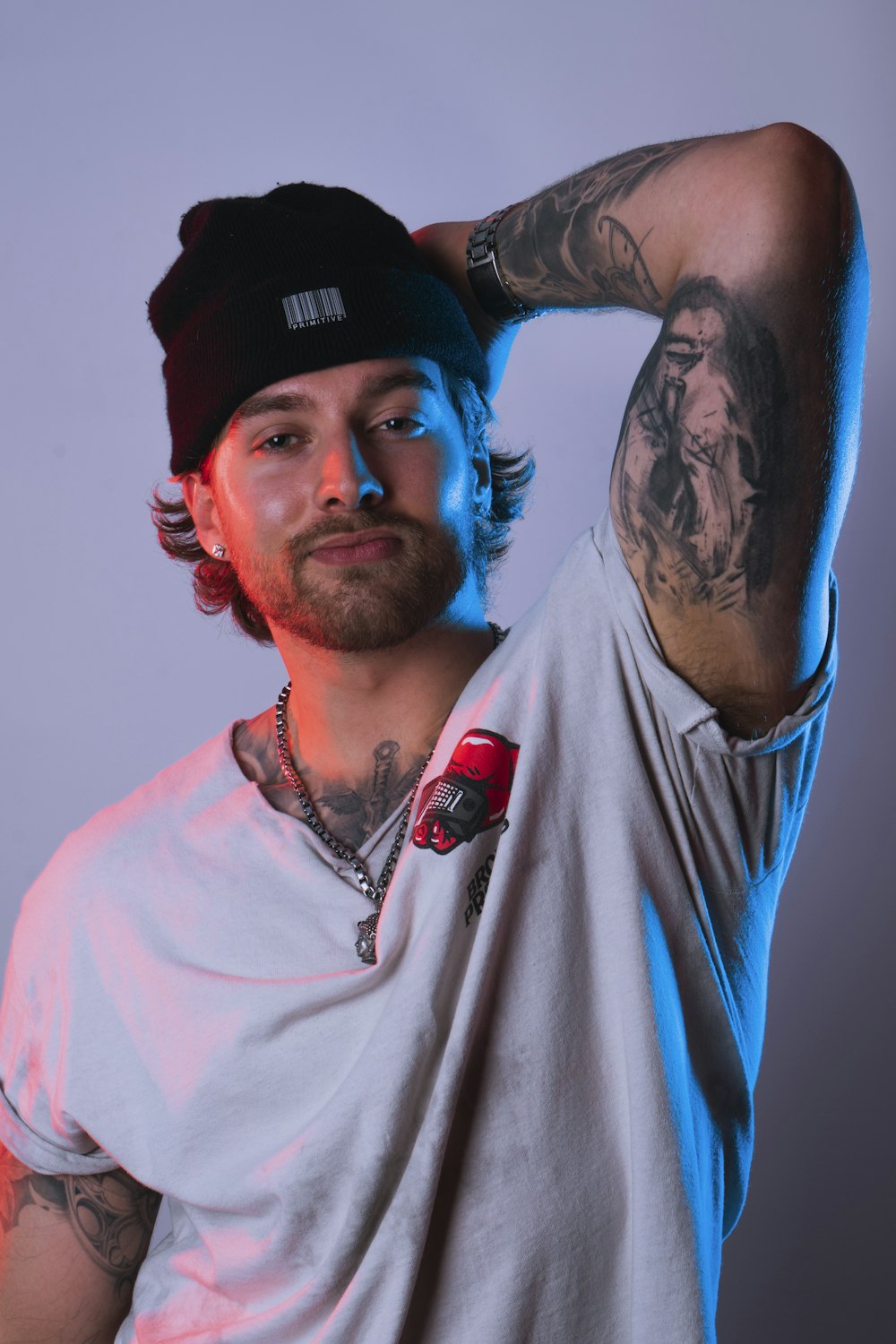 Hombre con camisa blanca de cuello redondo y gorra negra ajustada