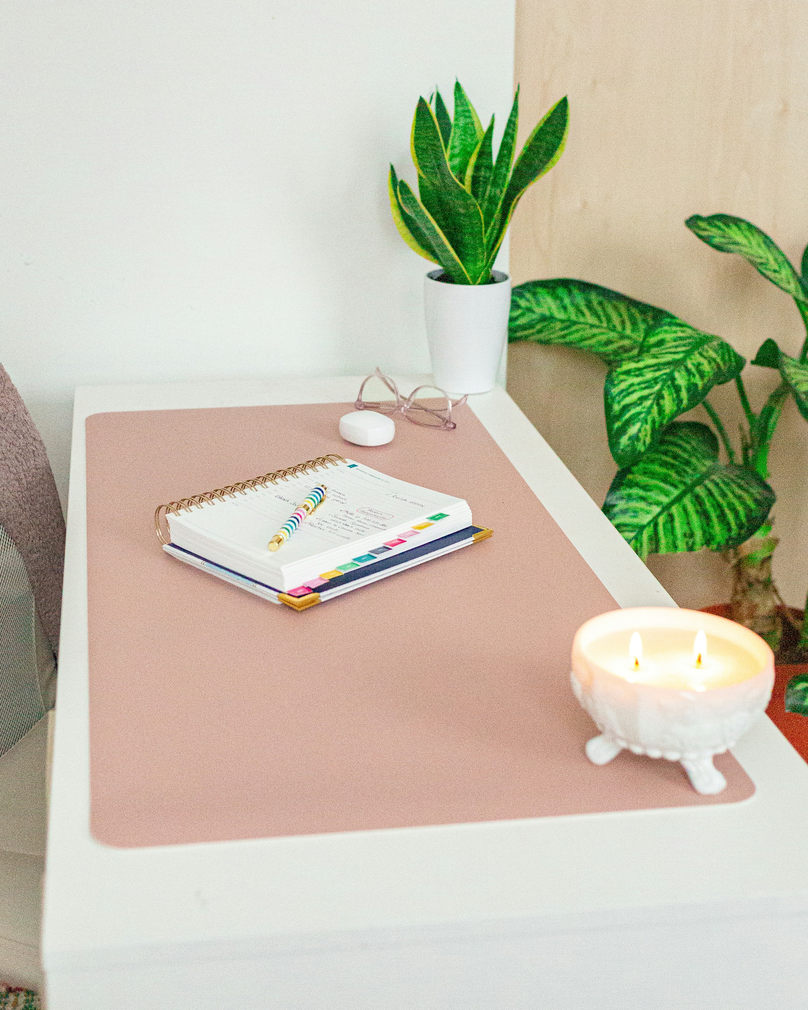 A table with a notebook and a candle on it