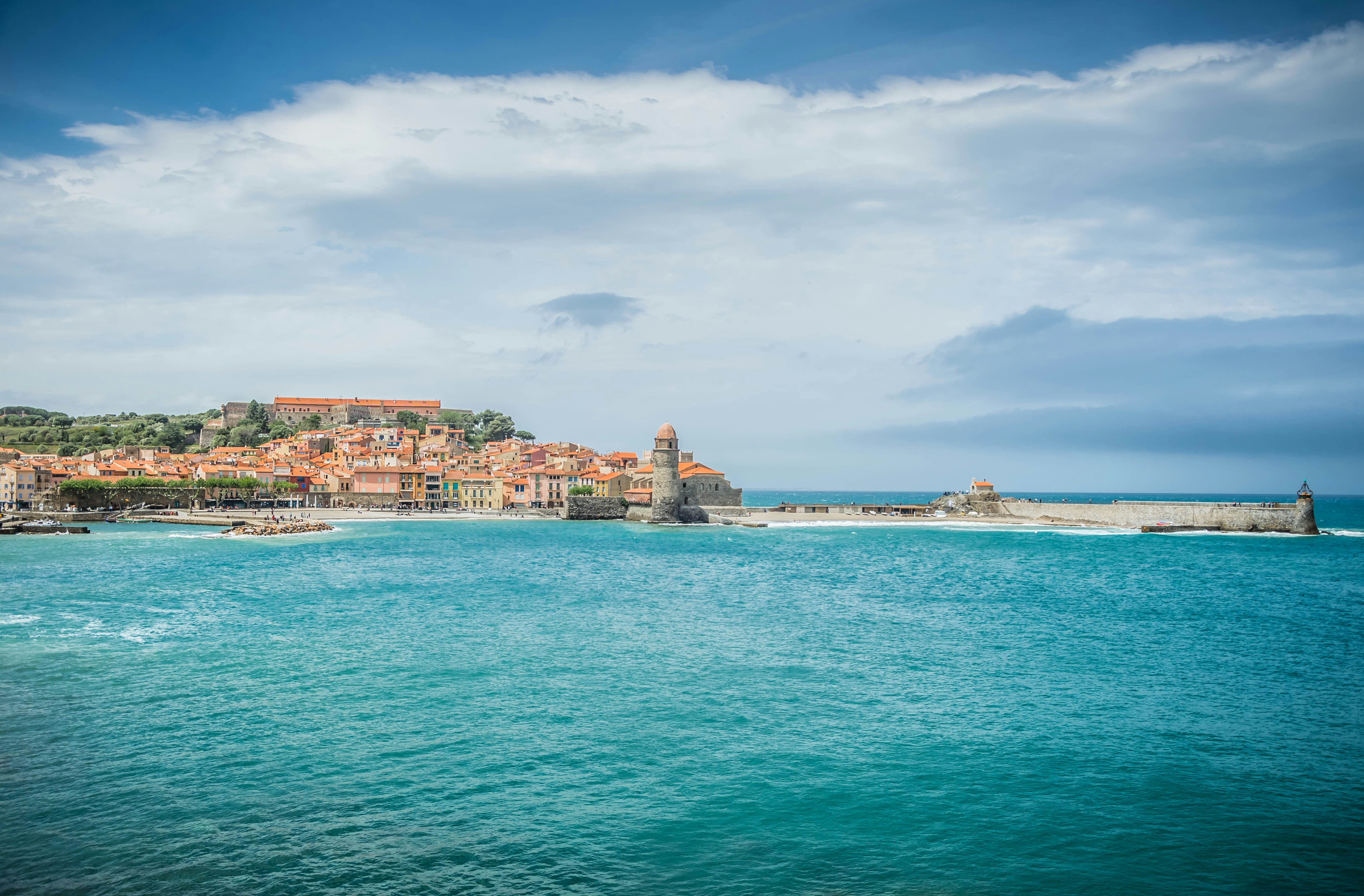 city buildings near body of water under cloudy sky during daytime