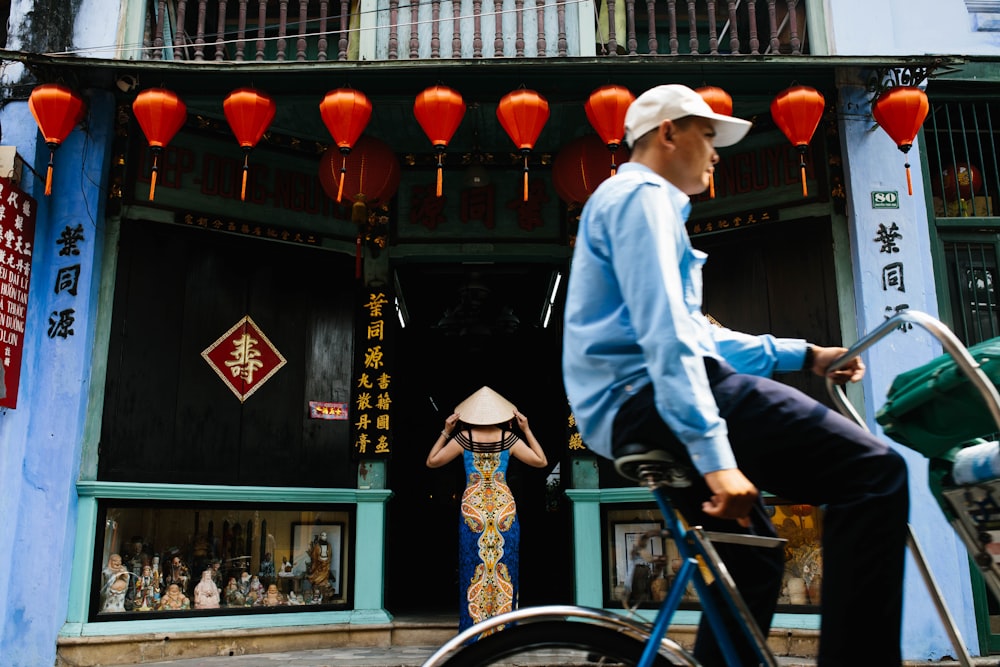 man in white dress shirt riding on blue bicycle during daytime