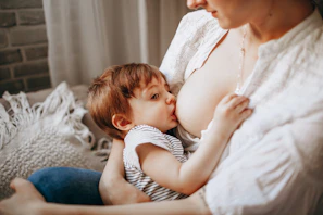 A cozy scene of a mother gently breastfeeding her baby, bathed in soft purple light.