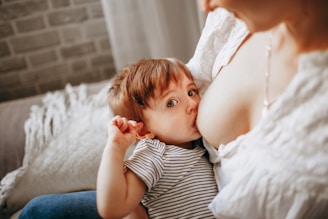 girl in white and black striped tank top lying on bed