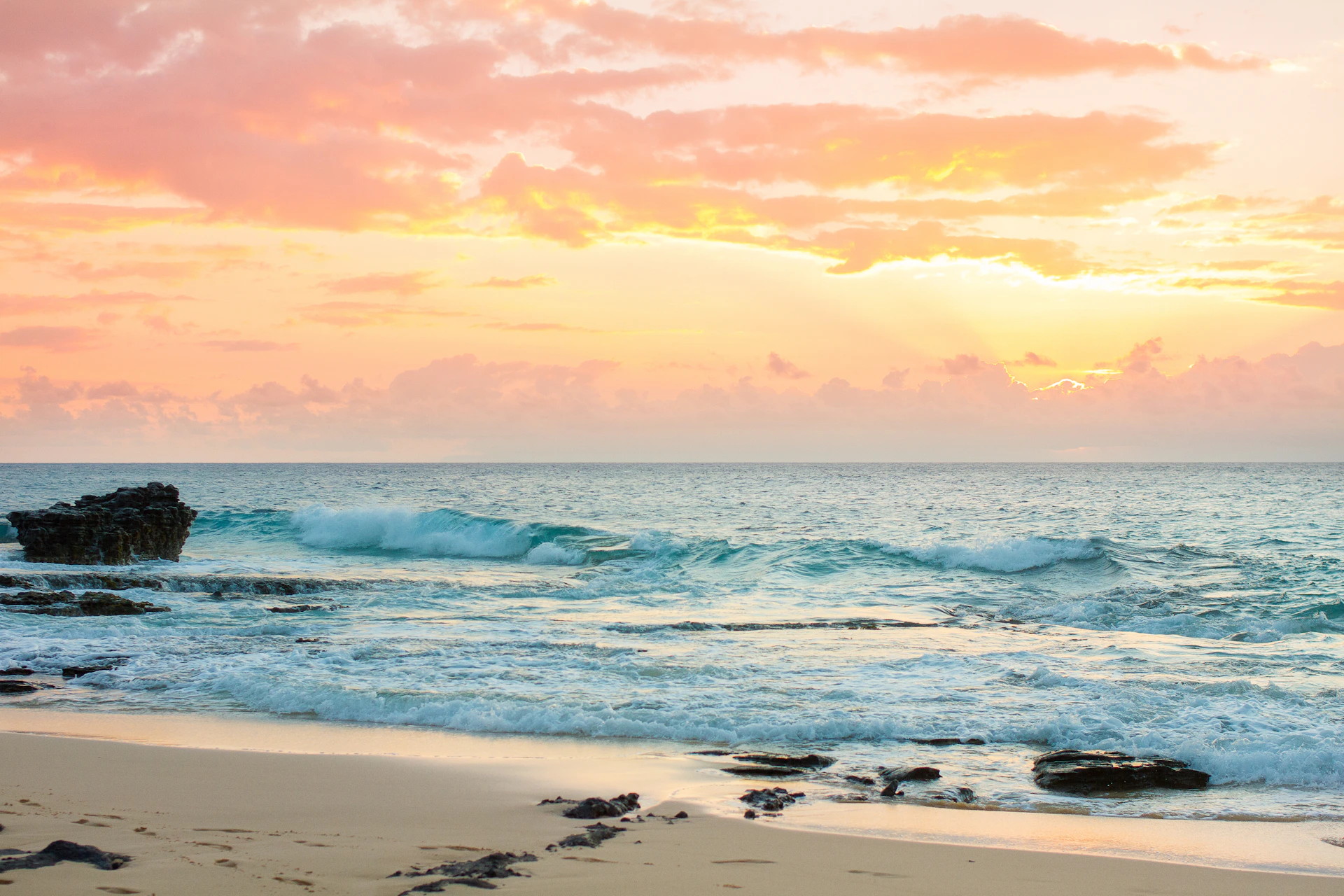 A sandy beach with waves coming in to shore