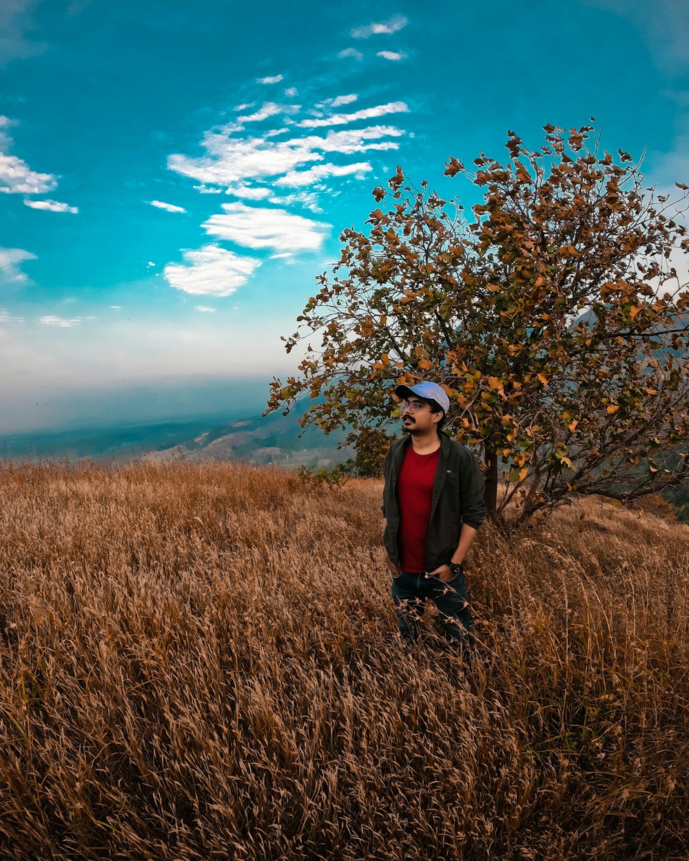 woman in black jacket standing on brown grass field during daytime