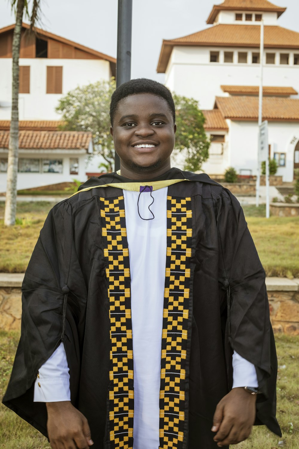 boy in black and yellow academic dress