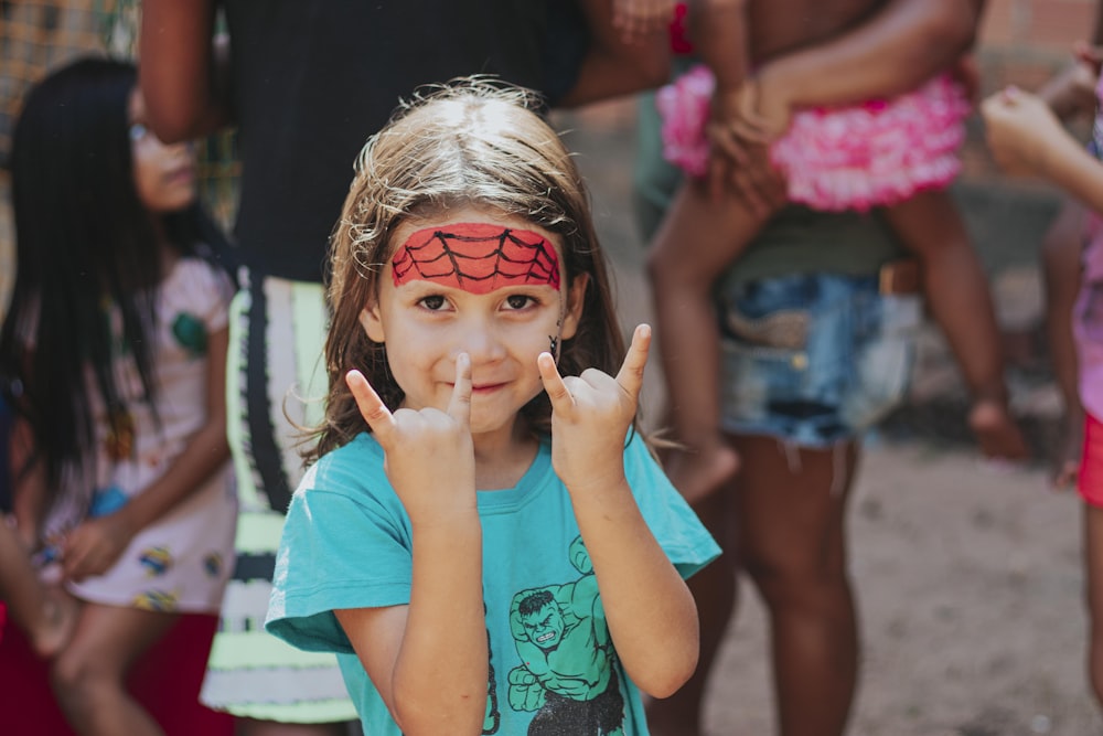 a little girl with her face painted like a spiderman