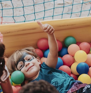 girl in blue shirt lying on yellow inflatable pool