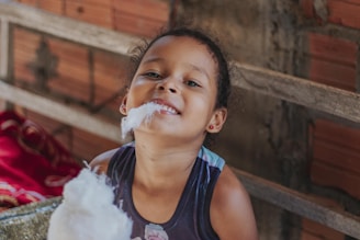 girl in blue tank top with white powder on her face