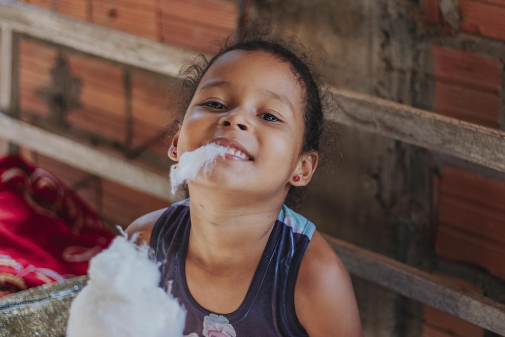 girl in blue tank top with white powder on her face