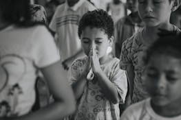 Children praying together in a bright Sunday school classroom.