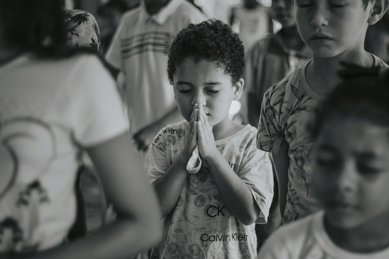 Niño rezando con las manos juntas