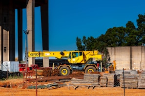yellow and black heavy equipment near brown wooden post