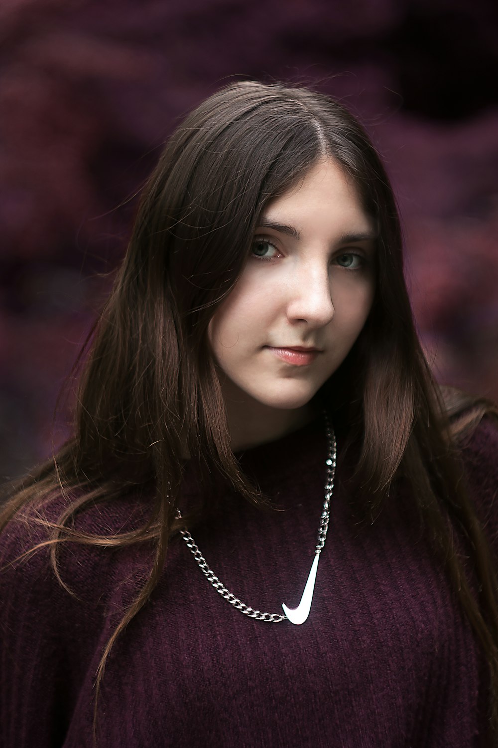 woman in purple knit sweater wearing silver necklace